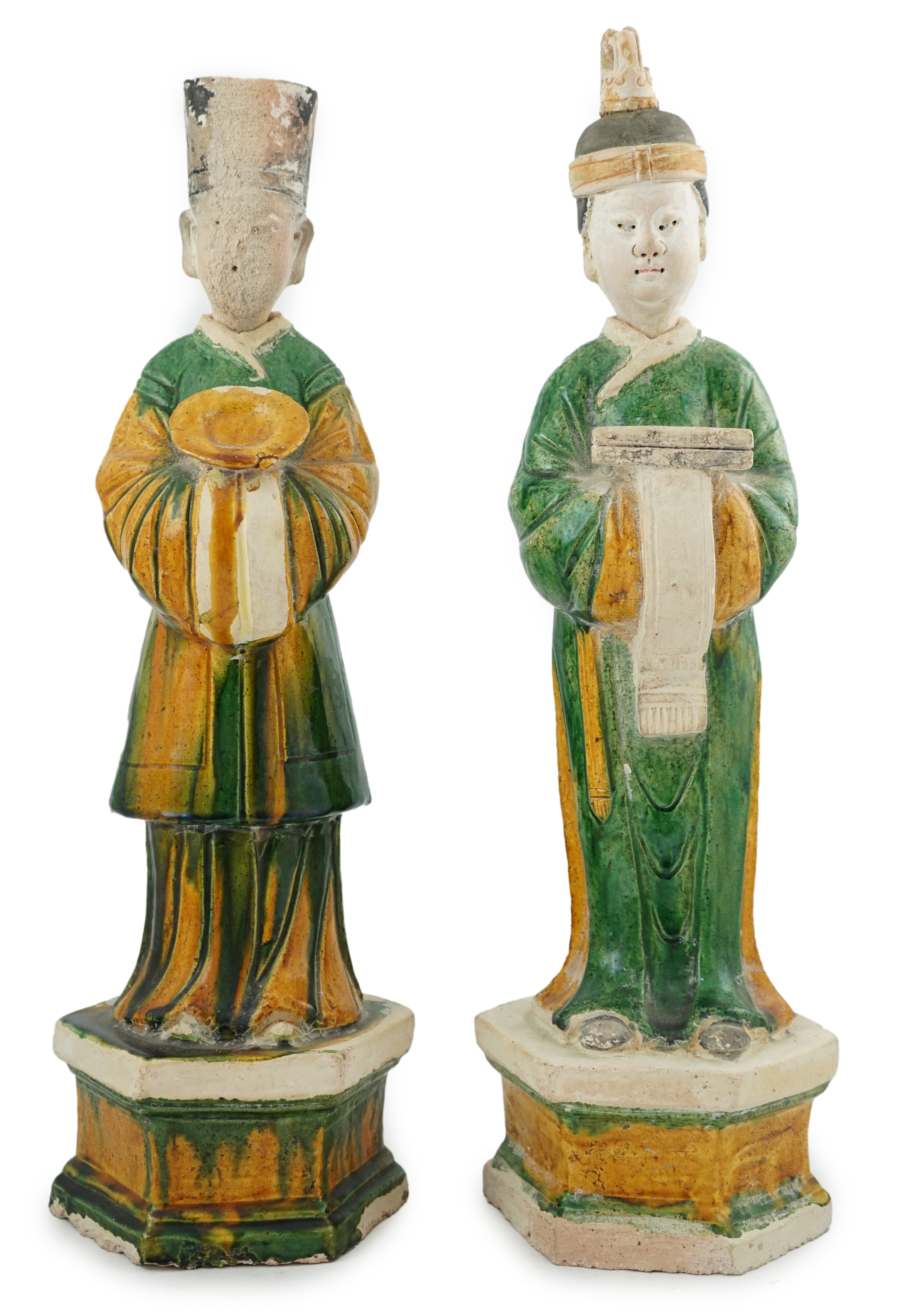 Two tall Chinese sancai figures of attendants, Ming dynasty, the male figure holding a dish and the female figure a box, each standing on a hexagonal base, largest 47cm high. Condition - some wear to face